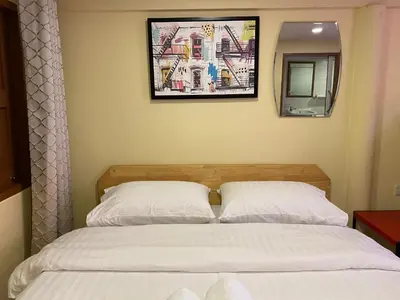 a bedroom with a bed and a picture on the wall at Bed in Beyt Boutique Hotel in Nonthaburi