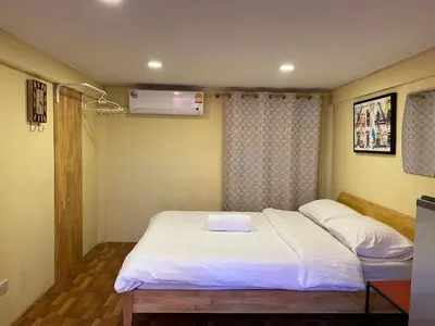 a small room with a bed and a fan at Bed in Beyt Boutique Hotel in Nonthaburi