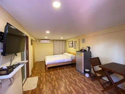 a room with a bed and a table and a tv at Bed in Beyt Boutique Hotel in Nonthaburi