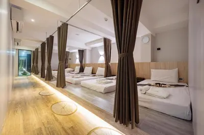 a row of beds in a hotel room at Loft Bangkok Hotel in Bangkok