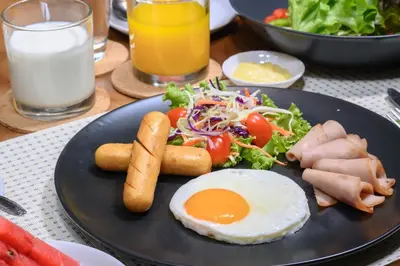 a plate of food with an egg and a salad at Loft Bangkok Hotel in Bangkok