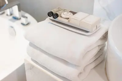 a pile of towels on a shelf in a bathroom at Loft Bangkok Hotel in Bangkok