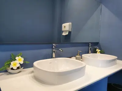 a bathroom with two sinks and a blue wall at A Bangkok Journey in Bangkok