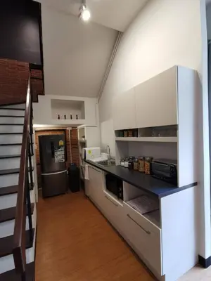 a kitchen with a counter and a refrigerator at A Bangkok Journey in Bangkok