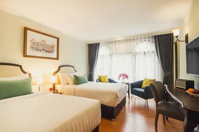 a hotel room with two beds and a desk at Daraya Boutique Hotel in Bangkok