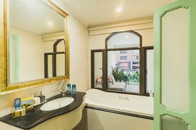 a bathroom with a sink and a tub and a window at Daraya Boutique Hotel in Bangkok