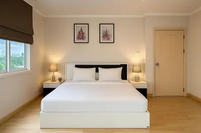 a bedroom with a large white bed and two lamps at PACIFIC RESIDENCE 39 in Bangkok