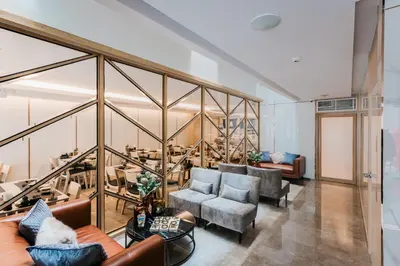 a living room with couches and chairs and glass walls at Artino Hotel Silom in Bangkok