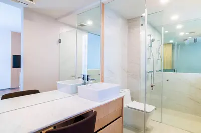 a bathroom with two sinks and a glass shower at Artino Hotel Silom in Bangkok