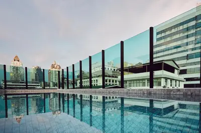 a swimming pool in front of a building at Artino Hotel Silom in Bangkok