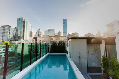 a swimming pool on the roof of a building with a city skyline at Artino Hotel Silom in Bangkok