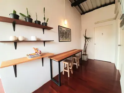 a room with a wooden table and shelves on the wall at Pingplalee Female House in Bangkok