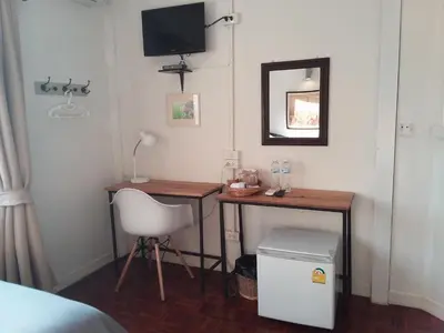 a bedroom with a desk and a chair and a mirror at Pingplalee Female House in Bangkok