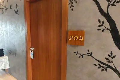 a door with a sign on a wall at Lilliput Riverside Bangkachao in Samutprakarn