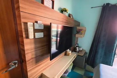 a television on a wooden wall in a bedroom at Lilliput Riverside Bangkachao in Samutprakarn