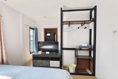 a bedroom with a bed and a tv in a room at Lilliput Riverside Bangkachao in Samutprakarn
