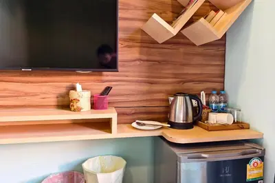 a kitchen with a tv on a wooden wall at Lilliput Riverside Bangkachao in Samutprakarn