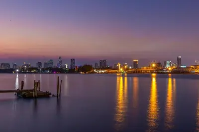 a view of a city skyline at night at Lilliput Riverside Bangkachao in Samutprakarn