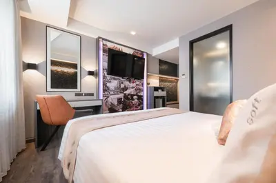 a hotel room with a large bed and a tv at Aspira Gems Center Silom in Bangkok