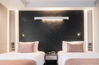 two beds sitting next to each other in a room at Aspira Gems Center Silom in Bangkok