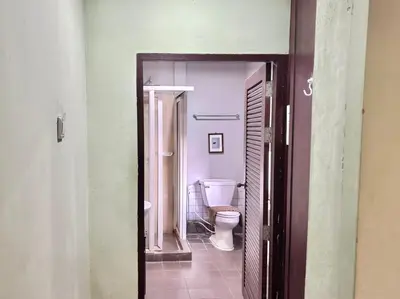 a bathroom with a toilet and a door open at Sabye Bangkok in Bangkok