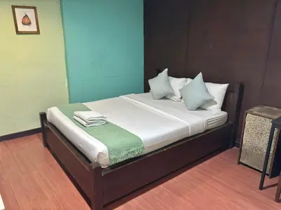 a bed with white sheets and blue pillows on it at Sabye Bangkok in Bangkok