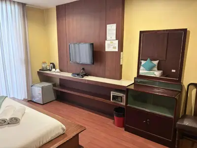 a hotel room with a bed and a tv at Sabye Bangkok in Bangkok
