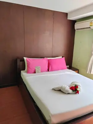 a large white bed with pink pillows at Sabye Bangkok in Bangkok