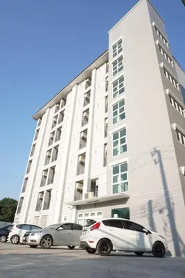 a white building with cars parked in front of it at JVAPLACE in Nonthaburi