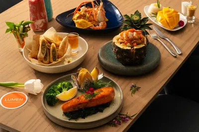a wooden table with plates of food on it at Lumen Bangkok Srinakarin in Bangkok