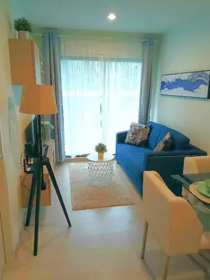 a living room with a blue couch and a window at Moonlight Goddess in Bangkok