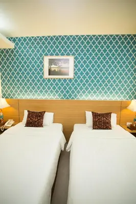 two beds in a room with a blue and white wallpaper at P2 Boutique in Bangkok