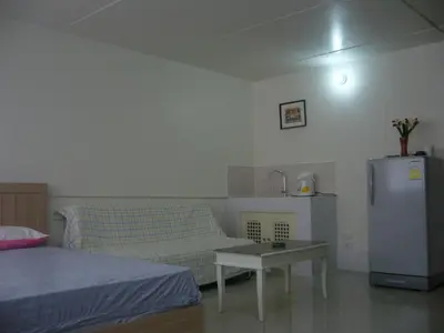 a living room with a couch and a refrigerator at IMPACT Don Mueang Bangkok Guest House in Nonthaburi
