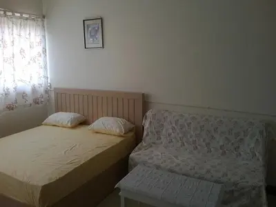 two twin beds in a room with a window at IMPACT Don Mueang Bangkok Guest House in Nonthaburi