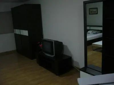 a living room with a television and a mirror at IMPACT Don Mueang Bangkok Guest House in Nonthaburi
