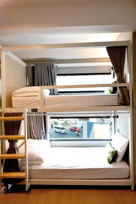 two bunk beds in a room with a window at Siam Eco Hostel in Bangkok