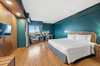 a bedroom with a bed and a blue wall at Town in Town Hotel Bangkok in Bangkok