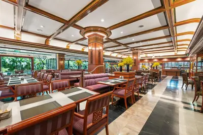a restaurant with tables and chairs in a room at Town in Town Hotel Bangkok in Bangkok