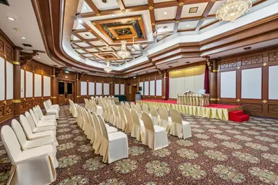a banquet hall with white chairs and a stage at Town in Town Hotel Bangkok in Bangkok