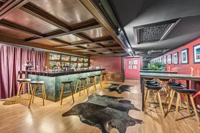 a bar with a green counter and bar stools at Town in Town Hotel Bangkok in Bangkok