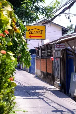 a street with a sign on the side of a building at U-need Guesthouse95 in Bangkok