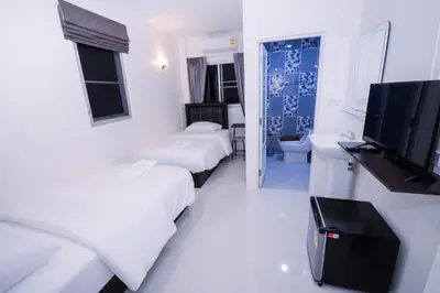 a hotel room with two beds and a flat screen tv at U-need Guesthouse95 in Bangkok