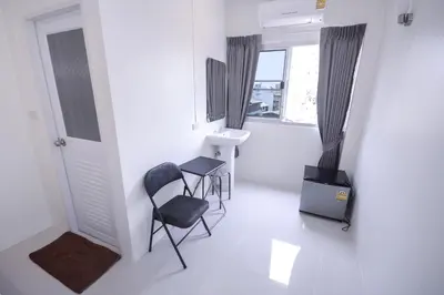 a white room with two chairs and a sink at U-need Guesthouse95 in Bangkok