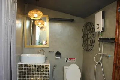 a bathroom with a sink and a toilet and a mirror at Do Dee cafe in Bangkok