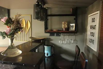 a dining room with a table with a vase of flowers on it at Do Dee cafe in Bangkok
