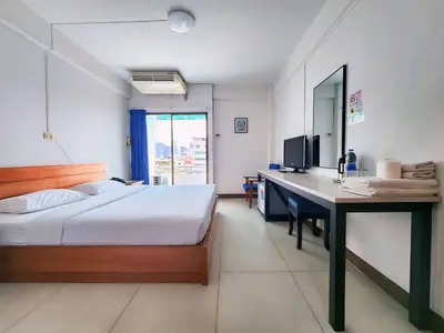 a bedroom with a bed and a desk with a computer at Siam Palace Hotel in Bangkok