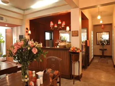 a dining room with a table with a vase of flowers at Sourire at Rattanakosin Island Hotel in Bangkok