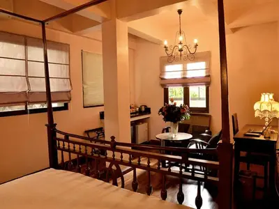 a bedroom with a bed and a dining room at Sourire at Rattanakosin Island Hotel in Bangkok