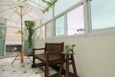 a chair and an umbrella in a room with windows at Sourire at Rattanakosin Island Hotel in Bangkok