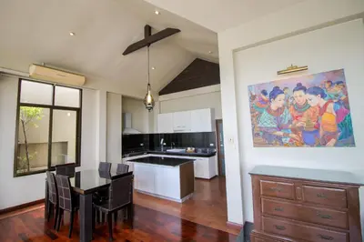 a kitchen with a dining table and a painting on the wall at Sourire at Rattanakosin Island Hotel in Bangkok